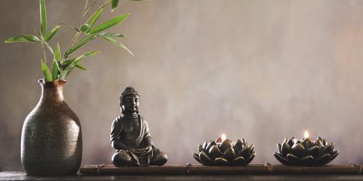Buddha soška s rostlinnou a svíčkami